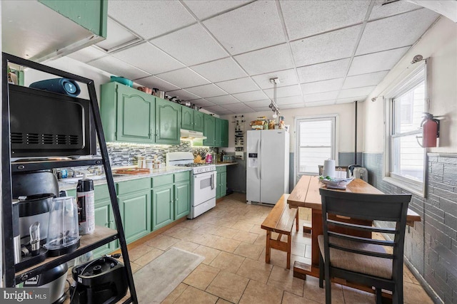 kitchen featuring a drop ceiling, white appliances, light countertops, and green cabinetry