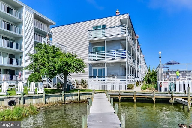 view of dock featuring ac unit and a water view