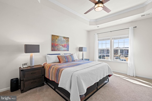 bedroom with visible vents, a raised ceiling, baseboards, and crown molding