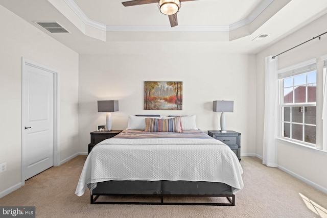 bedroom with visible vents, a raised ceiling, and light carpet