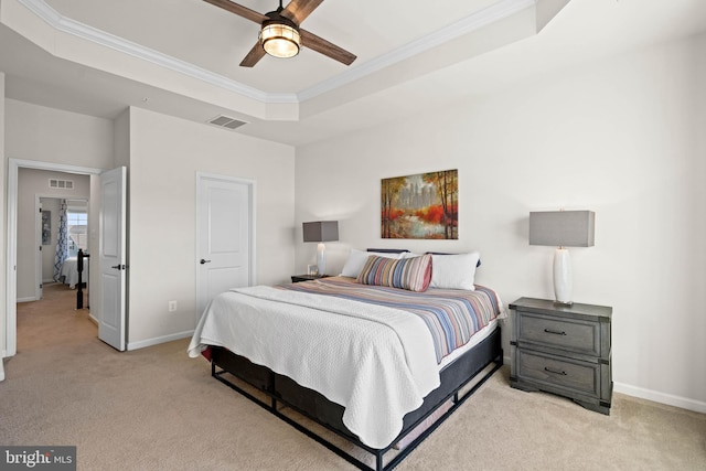 bedroom with light carpet, visible vents, a raised ceiling, and baseboards