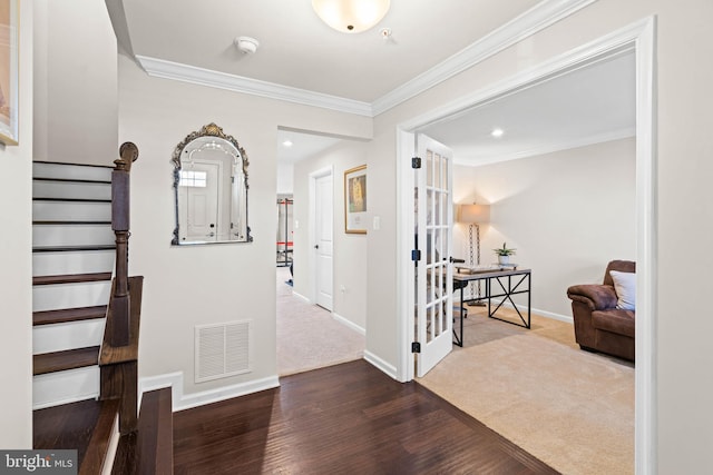 foyer entrance featuring baseboards, visible vents, stairs, dark wood-type flooring, and crown molding