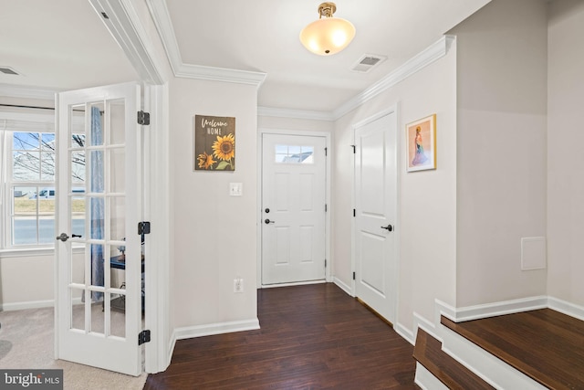 foyer with visible vents, wood finished floors, baseboards, and ornamental molding