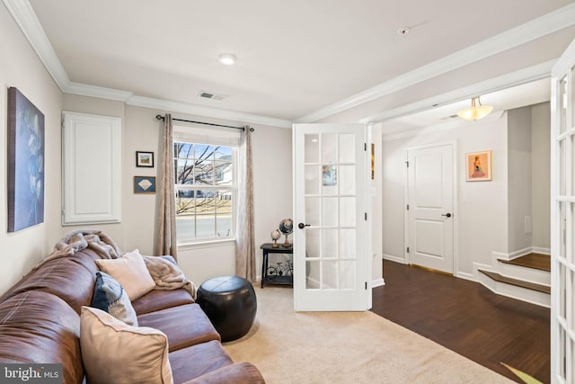 living room with visible vents, ornamental molding, wood finished floors, french doors, and carpet