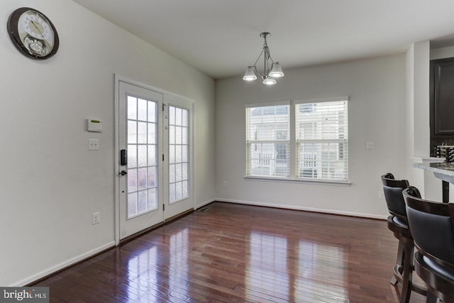 dining area with baseboards and dark wood-style flooring