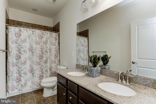 bathroom featuring a sink, toilet, double vanity, and tile patterned floors