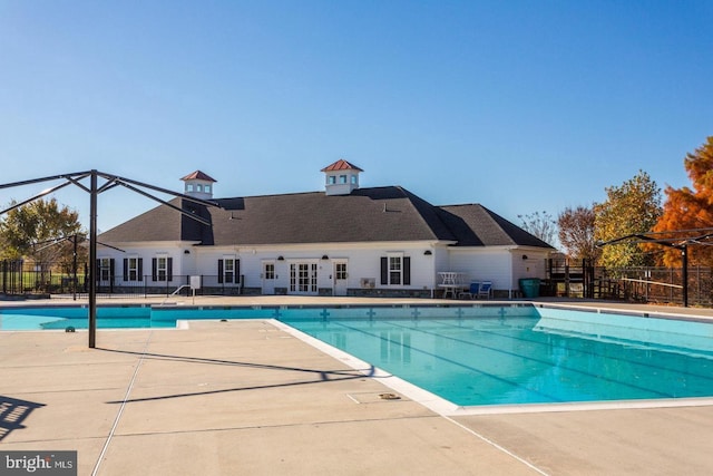 community pool featuring a patio and fence