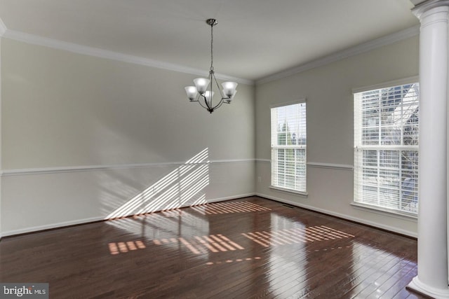 interior space featuring ornamental molding, wood-type flooring, an inviting chandelier, baseboards, and ornate columns