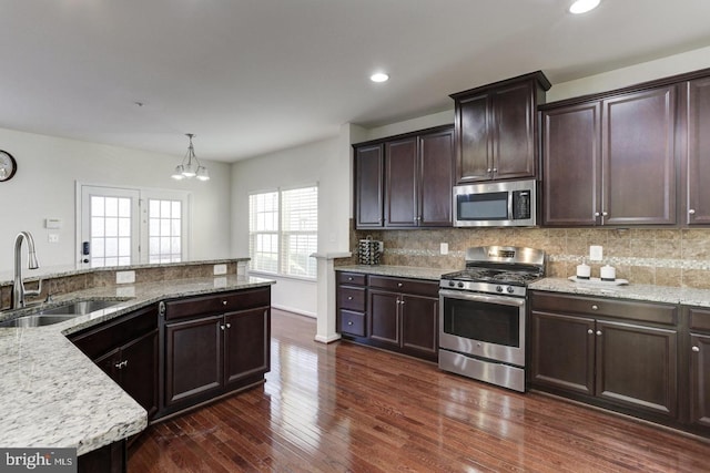 kitchen with decorative backsplash, stainless steel appliances, dark wood-type flooring, and a sink