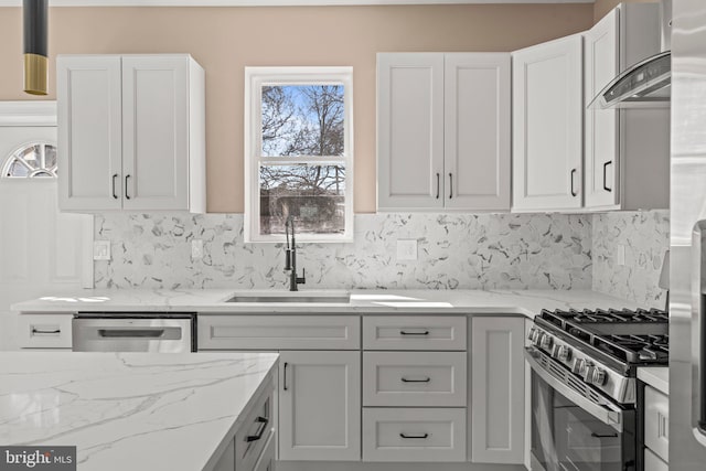 kitchen with light stone counters, tasteful backsplash, appliances with stainless steel finishes, and a sink