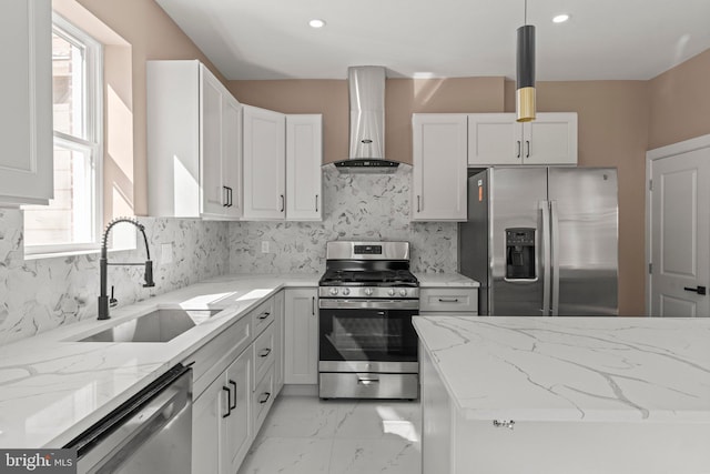 kitchen featuring marble finish floor, a sink, light stone counters, stainless steel appliances, and wall chimney exhaust hood