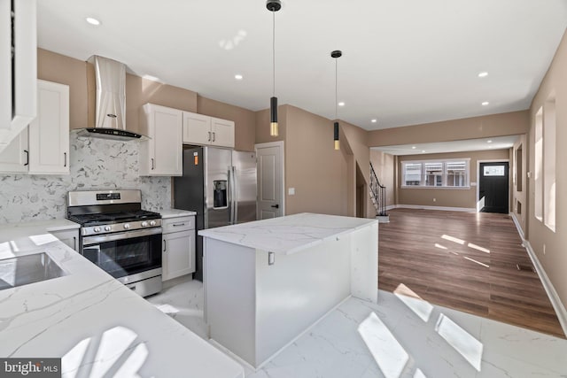 kitchen with tasteful backsplash, a kitchen island, wall chimney range hood, appliances with stainless steel finishes, and marble finish floor