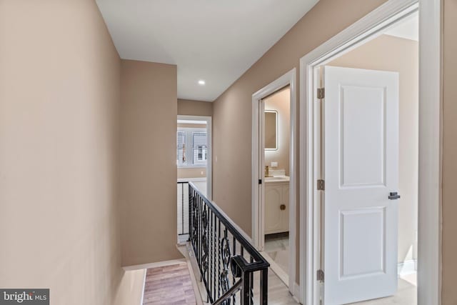 hall featuring recessed lighting, an upstairs landing, baseboards, and light wood finished floors