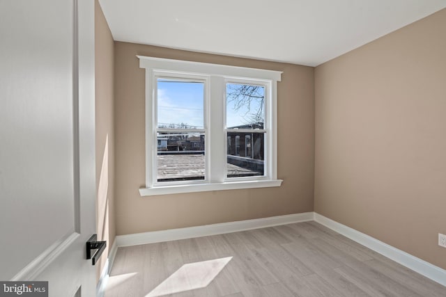 spare room with light wood-style flooring and baseboards