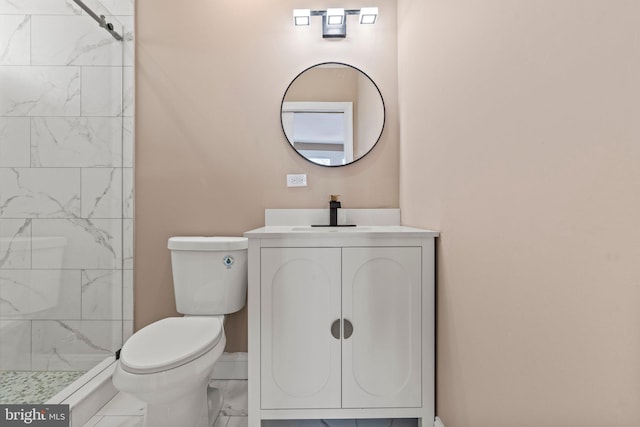 bathroom featuring toilet, marble finish floor, vanity, and a tile shower