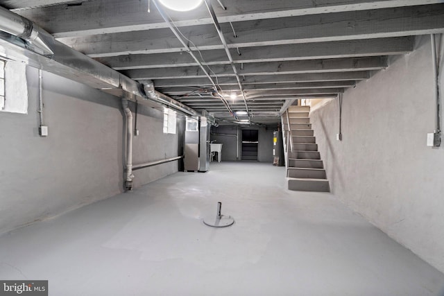 basement with stairs, heating unit, and a sink