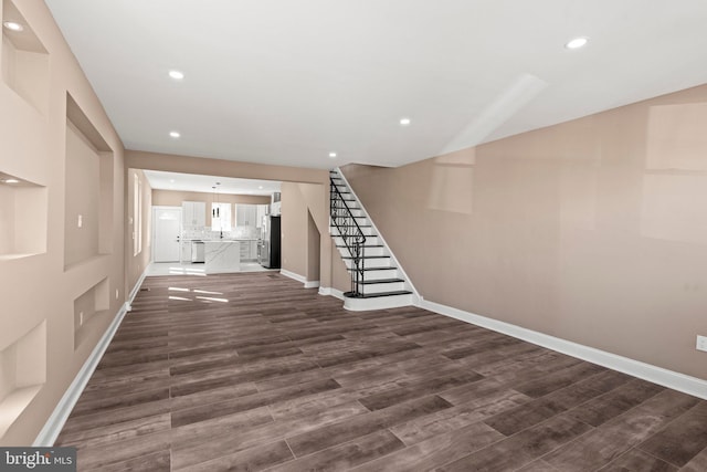 interior space featuring dark wood finished floors, stairway, and recessed lighting