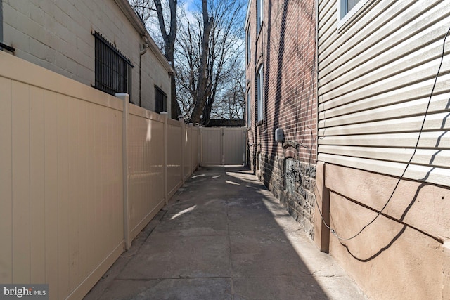 view of side of property featuring fence and brick siding