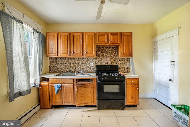 1121 E 22nd St, Wilmington, DE 19802 - kitchen with light countertops, baseboard heating, black gas range oven, and a sink