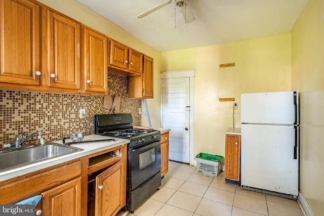 1121 E 22nd St, Wilmington, DE 19802 - kitchen with freestanding refrigerator, light tile patterned floors, a sink, backsplash, and gas stove