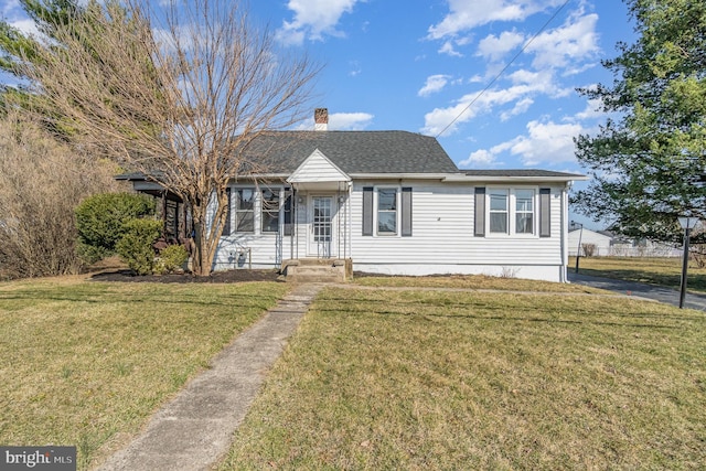 view of front of property with a chimney, a front yard, and a shingled roof