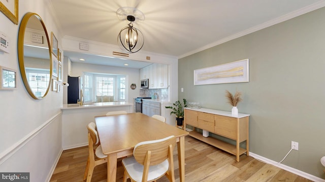 dining area with light wood-type flooring, baseboards, an inviting chandelier, and ornamental molding