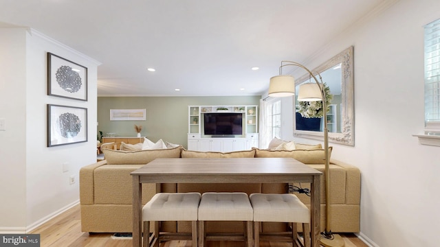 living area with recessed lighting, crown molding, light wood-type flooring, and baseboards