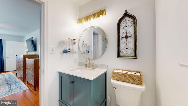 bathroom featuring toilet, hardwood / wood-style floors, and vanity