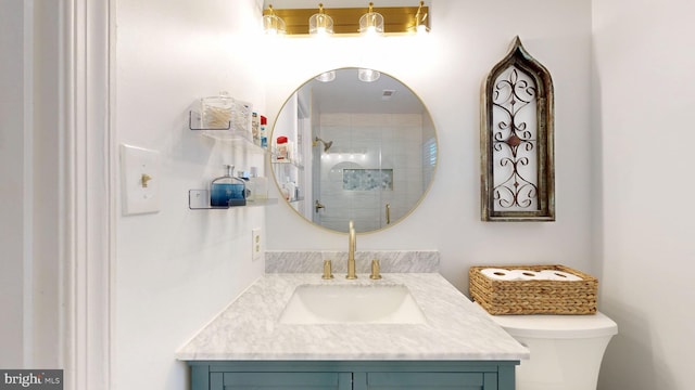 bathroom with toilet, vanity, and a tile shower