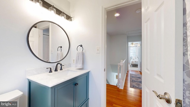 bathroom featuring toilet, vanity, and wood finished floors