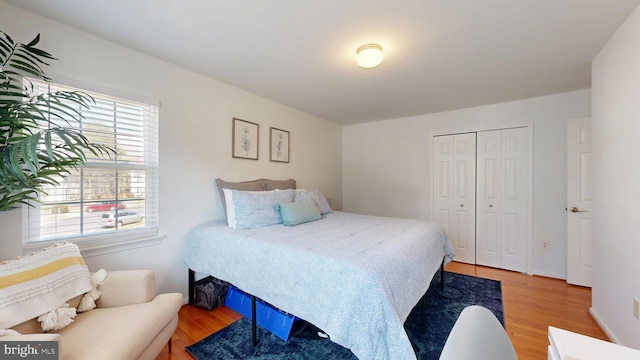 bedroom with light wood-type flooring and a closet