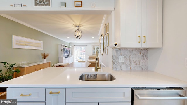 kitchen featuring ornamental molding, decorative backsplash, light countertops, dishwasher, and open floor plan