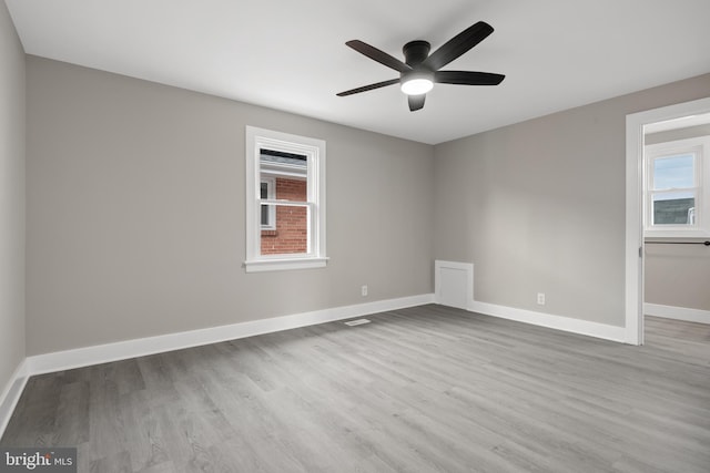 unfurnished room featuring a ceiling fan, wood finished floors, and baseboards