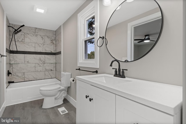 full bath featuring visible vents, toilet, wood finished floors, washtub / shower combination, and vanity