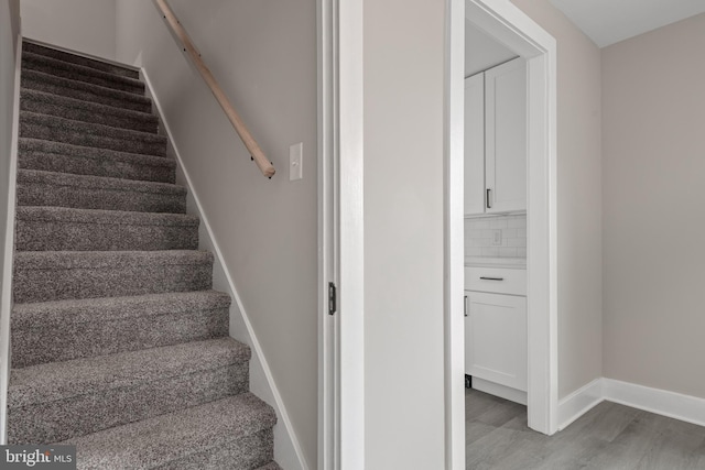 stairway with baseboards and wood finished floors