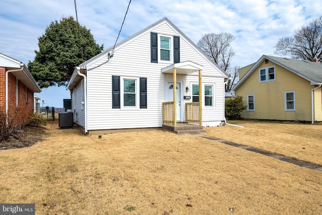 bungalow featuring a front lawn, central air condition unit, and fence