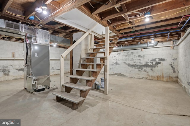 unfinished basement featuring stairway and heating unit