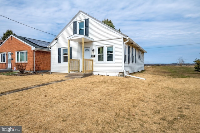 bungalow-style home with a front lawn and roof mounted solar panels