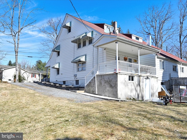 rear view of house with a yard and a chimney