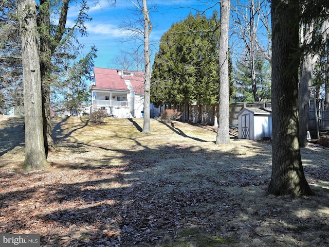 view of yard with an outbuilding, a storage shed, and fence