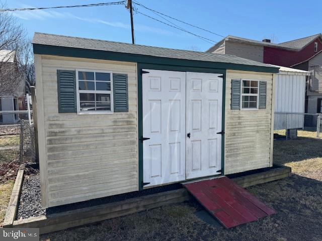 view of shed featuring fence