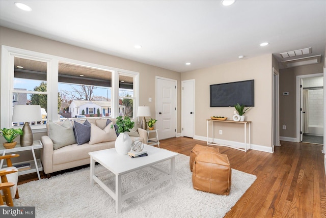 living room with recessed lighting, wood finished floors, visible vents, and baseboards