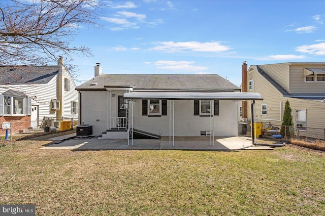 rear view of house with a patio, a lawn, brick siding, and fence