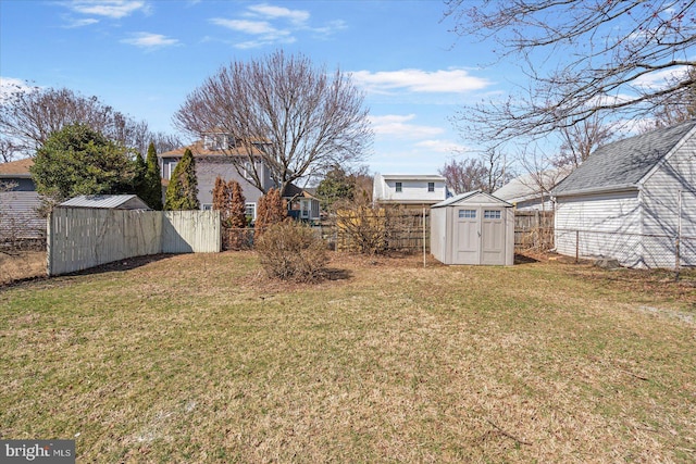 view of yard with an outbuilding, a storage shed, and a fenced backyard