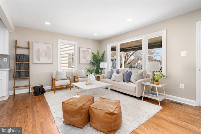 living area featuring recessed lighting, baseboards, visible vents, and light wood finished floors