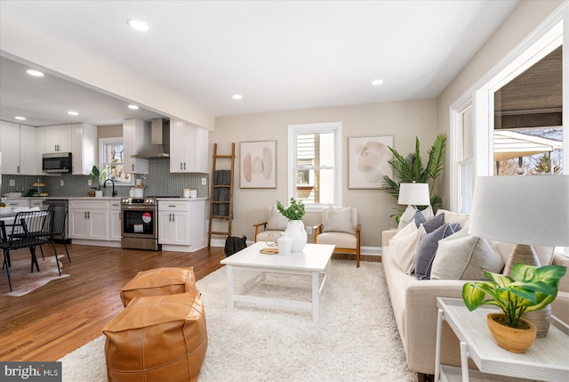 living room featuring recessed lighting, baseboards, and wood finished floors