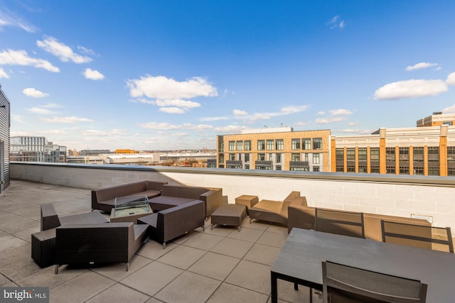 view of patio with a view of city and an outdoor living space with a fire pit