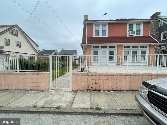 27 Wellington Rd, Upper Darby, PA 19082 - view of front of property featuring a gate, a chimney, cooling unit, fence, and brick siding