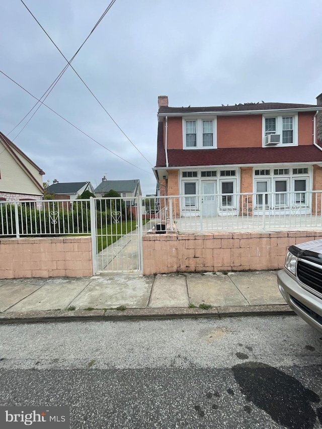 27 Wellington Rd, Upper Darby, PA 19082 - view of front of house featuring a chimney, a fenced front yard, cooling unit, and a gate