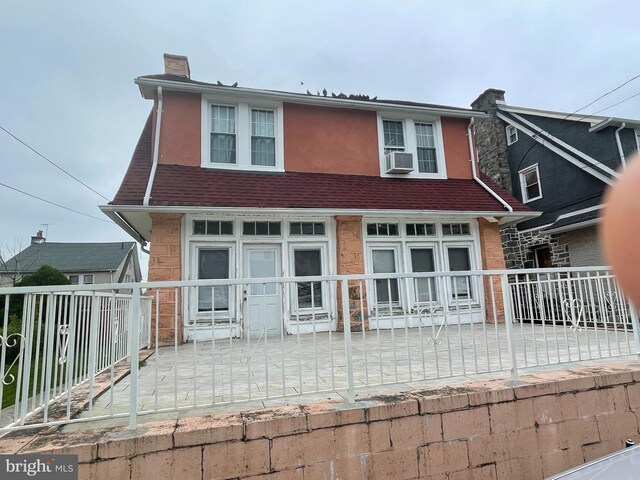27 Wellington Rd, Upper Darby, PA 19082 - view of front of property with a chimney, cooling unit, fence, and stucco siding